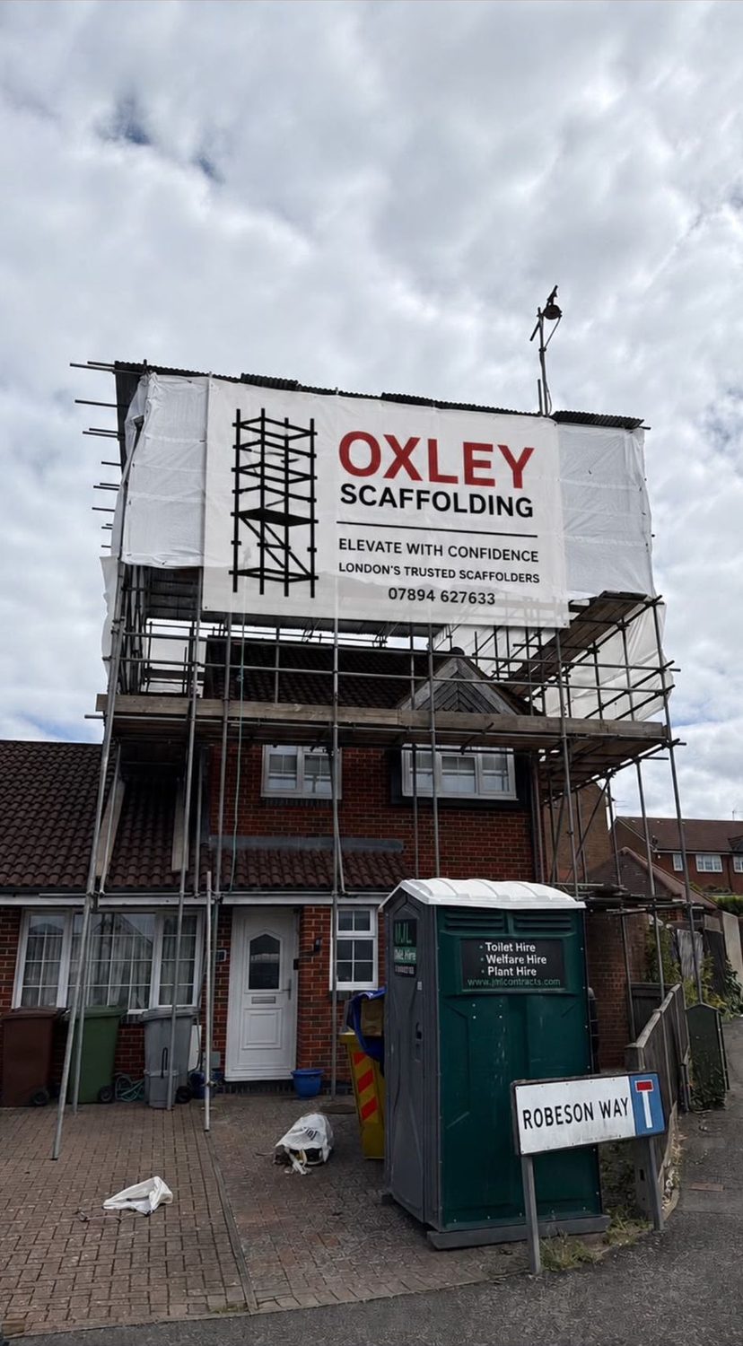 New build scaffold with Oxley banner and site welfare