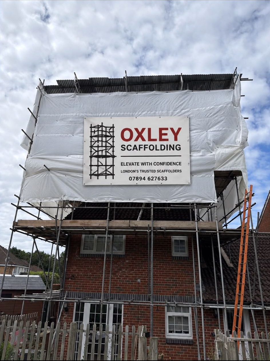 House wrapped in temporary roofing with Oxley banner